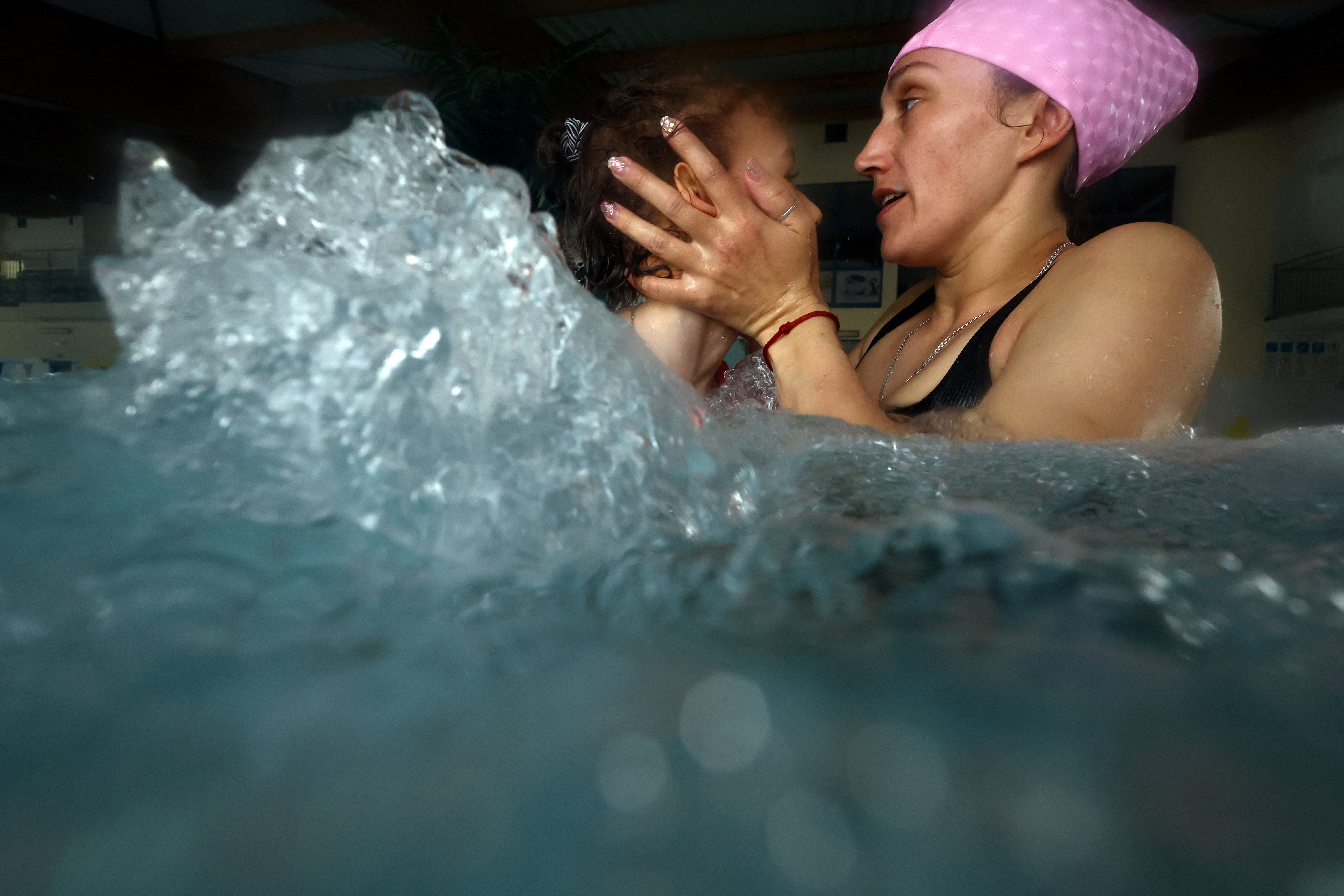 Alexandra assists Alevtina with physiotherapy in the pool