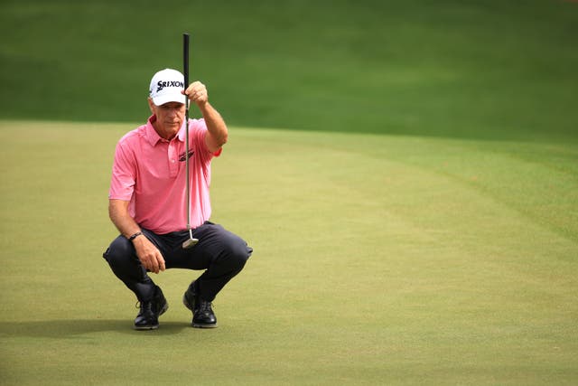 <p>Larry Mize eyes up a putt during the 2021 Masters</p>