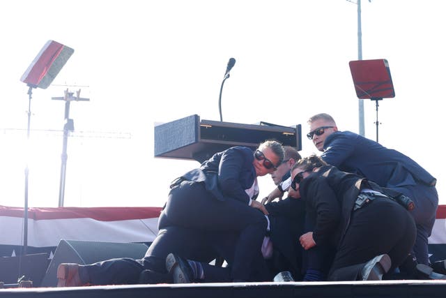 <p>Trump is taken to the floor by his security team during the assassination attempt in Butler, Pennsylvania on Saturday, July 13, 2024 </p>