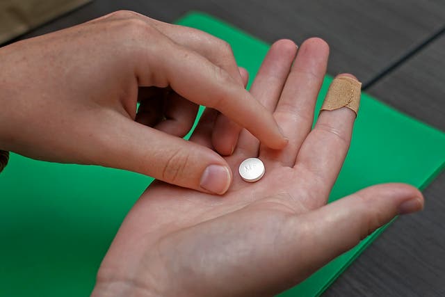 <p>A patient prepares to take a mifepristone pill to begin a medical abortion</p>