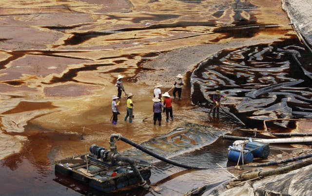 <p>Workers drain away polluted water at mine in Shanghang</p>