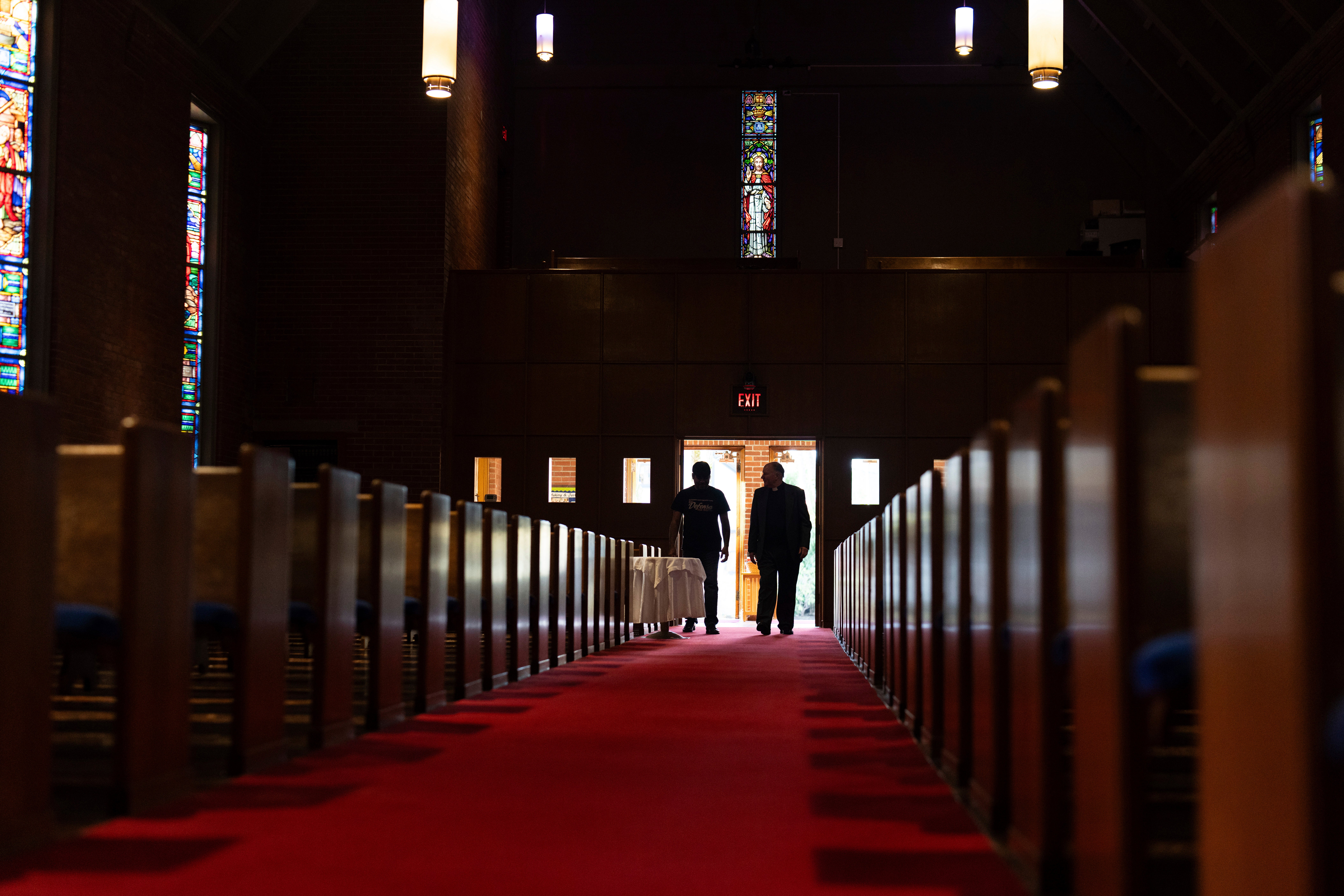 The Rev. W. J. Mark Knutson, right, walks with an El Salvadoran immigrant at the Augustana Lutheran Church