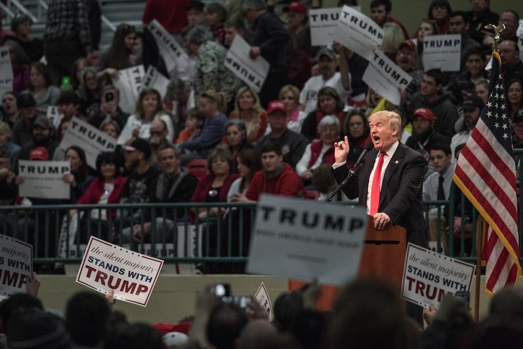 A 78-year-old man has been charged with assault after video captured him punching a black man at a Donald Trump rally.