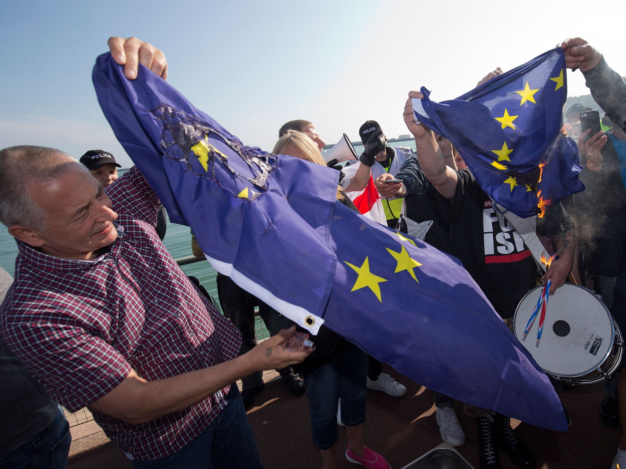 A group of far right protesters burn a European Union flag after a demonstration in Dover