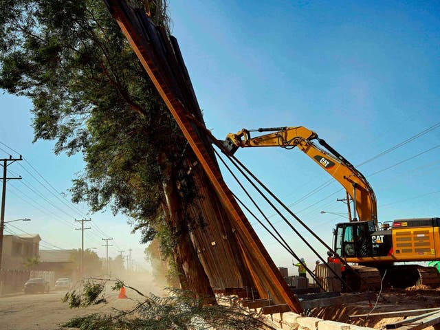 A construction crew works on a fallen section of the US-Mexico border wall as seen from Mexicali in Baja California 29 Jan 2020